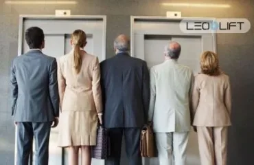 Lifty dlya TRTs yak unyknuty cherh i perevantazhennya Five businesspeople in suits stand with their backs to the camera, waiting at two elevator doors; LEO LIFT logo visible above.