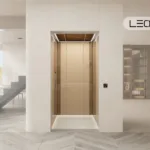 Modern home interior with a centered beige elevator doors; open-plan stairs to the left and a lounge to the right, LEO LIFT logo in the top-right.