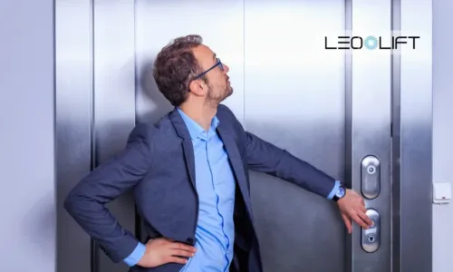 Man in a blue suit reaches for an elevator door handle, with the LEO LIFT logo in the top-right corner.